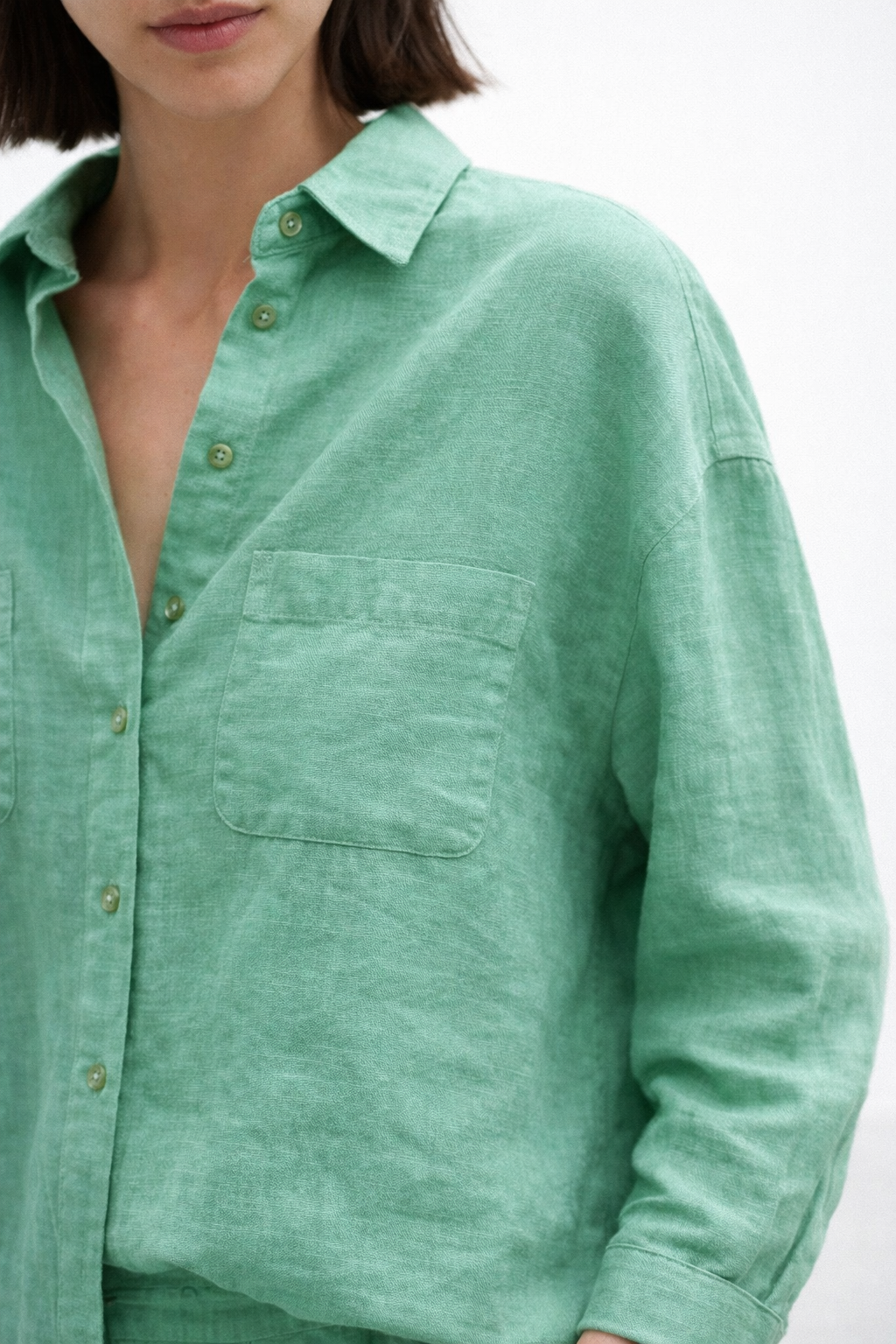 Close-up of Aura Green Linen shirt showcasing natural linen texture and chest pocket detailing