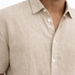 Close-up of natural linen fabric texture on earthy toned men’s shirt