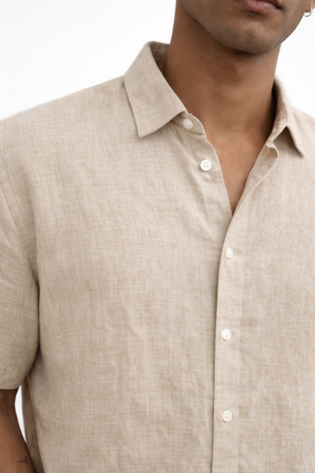 Close-up of natural linen fabric texture on earthy toned men’s shirt