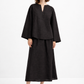Woman wearing Eclipse Black Linen Set featuring a relaxed notch-neck linen top and flowing midi skirt in a front pose.