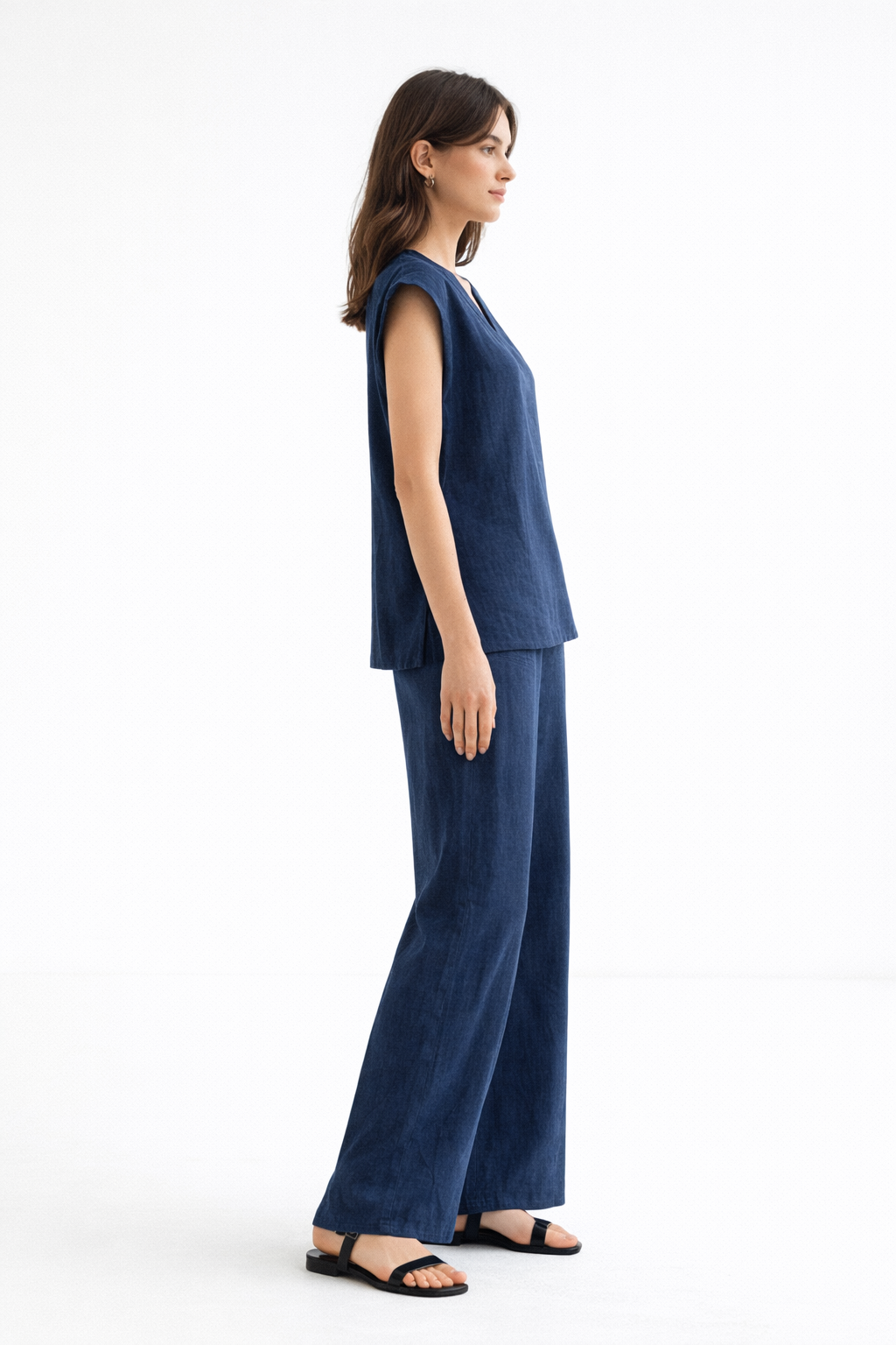 Side view of Ira Neel linen set highlighting the relaxed vest drape and fluid wide-leg pants