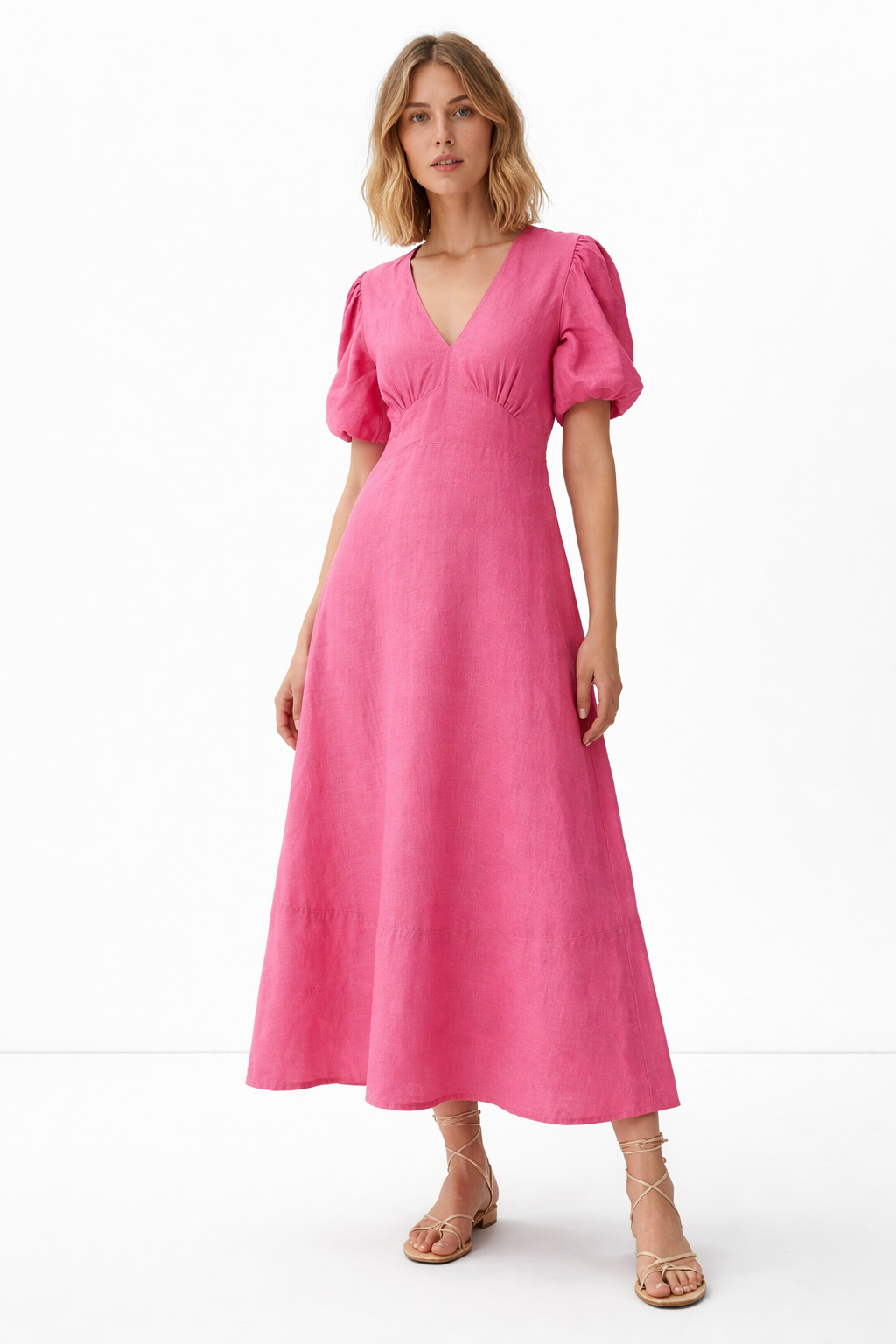 Woman wearing meadow linen dress standing in grassland, styled for summer lifestyle