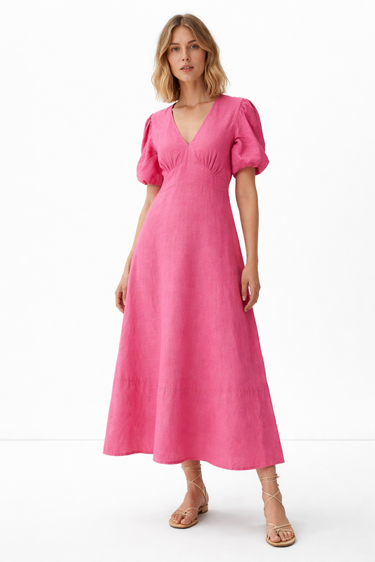 Woman wearing meadow linen dress standing in grassland, styled for summer lifestyle