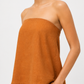 Close-up of Meher rust linen top showing natural linen texture and strapless neckline