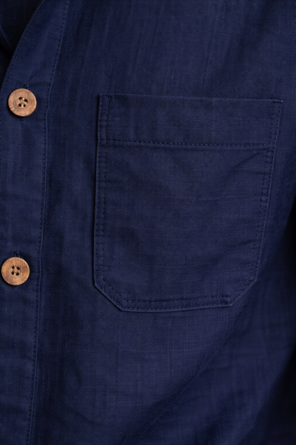 Close-up of navy blue pure linen fabric texture with natural weave and soft creases