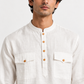 Close-up of the Safed white linen kurta highlighting its natural fabric texture, mandarin collar, wooden-toned buttons, and dual chest pockets.