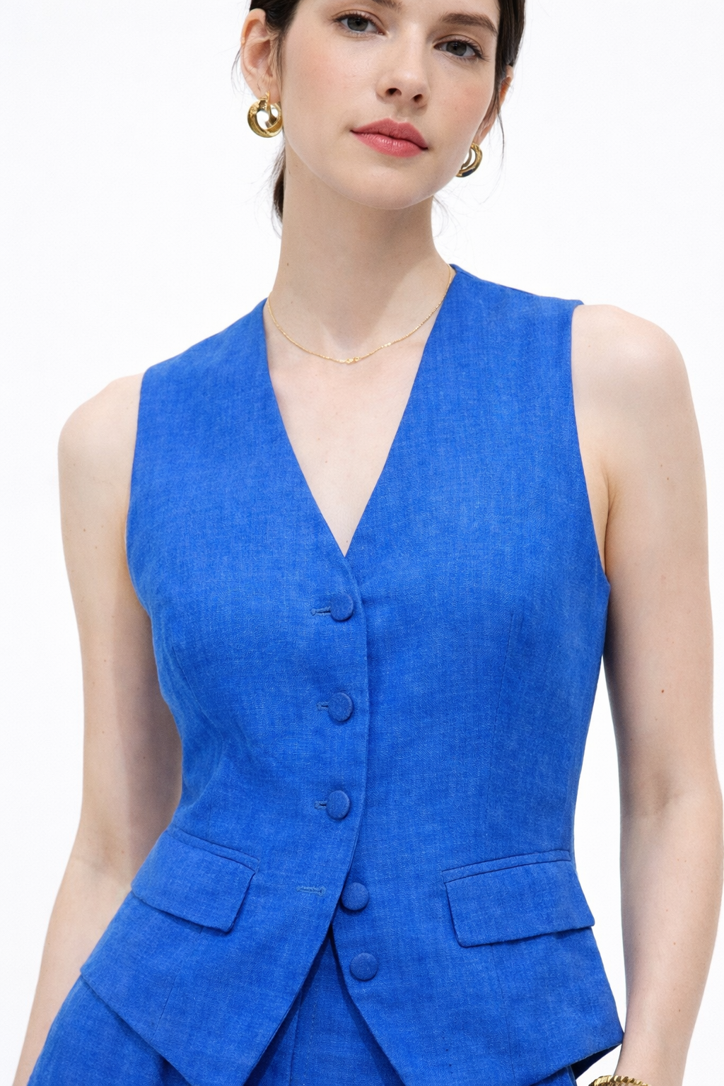 Close-up of blue linen vest fabric texture and button detailing