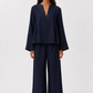 Woman wearing Twilight Navy Linen Set featuring a relaxed V-neck linen top and wide-leg trousers in pure navy linen.