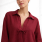 Close-up of Vanya Wine linen top showing tie-up neckline and fabric texture